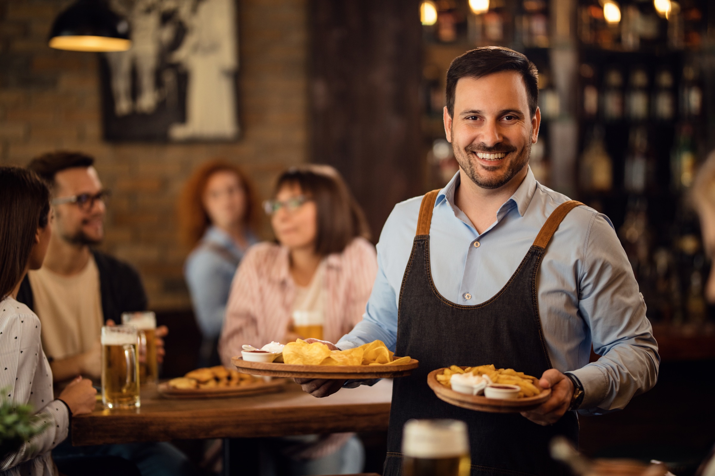 Garçom sorridente servindo pratos em um restaurante